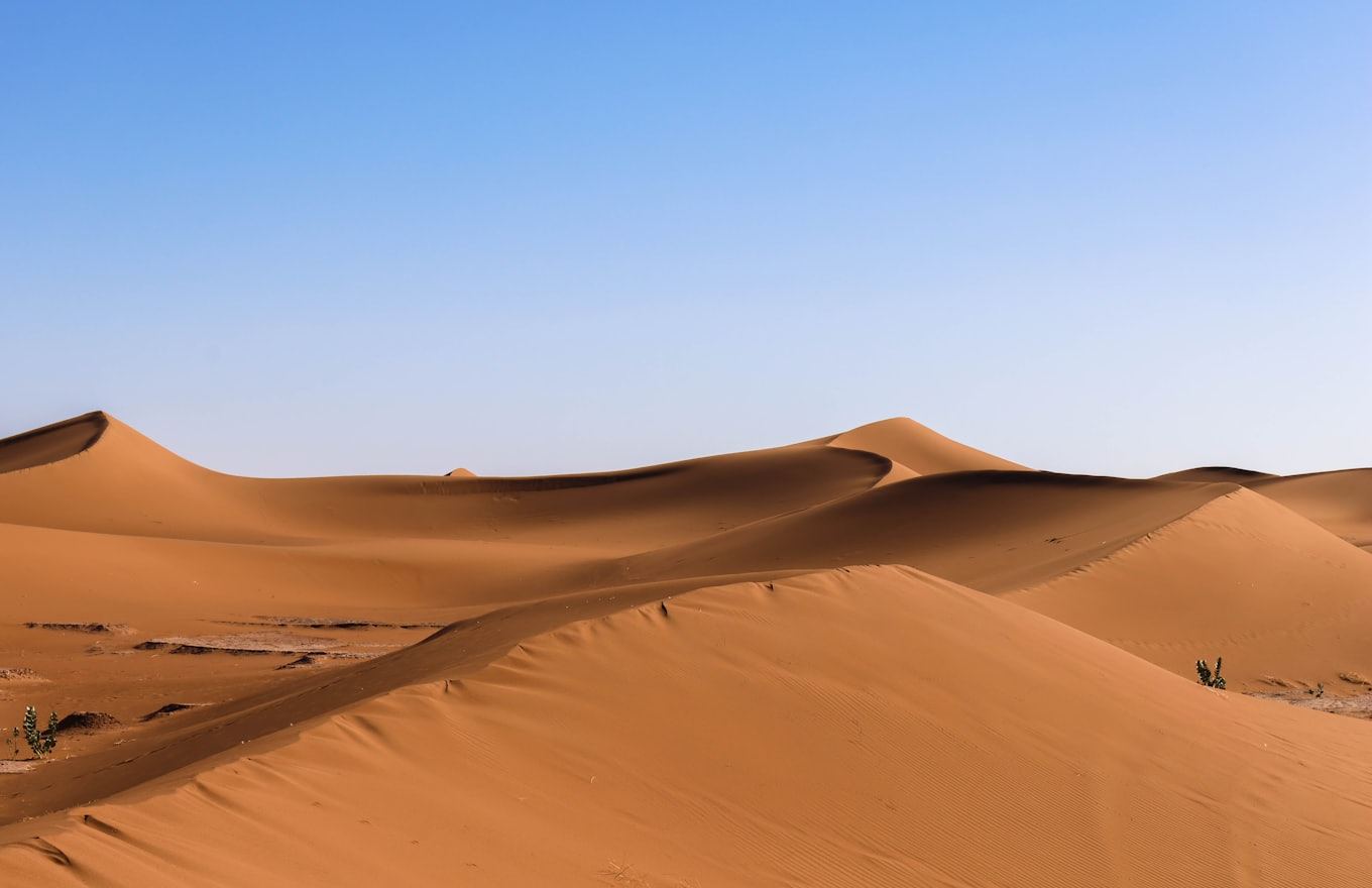 Golden desert sand dunes under a clear blue sky, the kind of dry climate where Arid outperforms condensation water generators